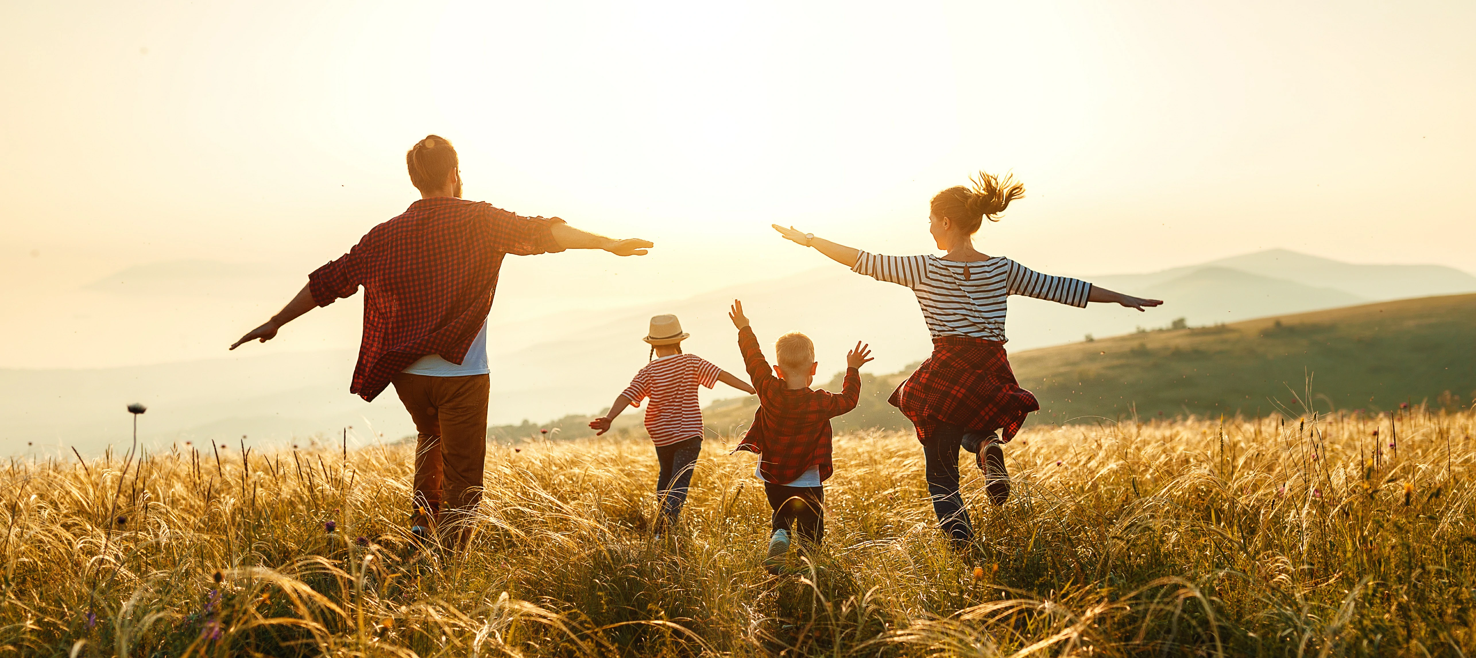 Bild einer glücklichen Familie vor Sonnenuntergang auf einem Feld